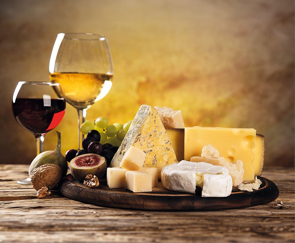 Auswahl von Käse und Wein auf einem Holztisch